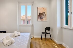 A bedroom with a bed, a chair, a window, and a painting. - Casa e Appartamento Vacanze Gallese 10 (Roma)