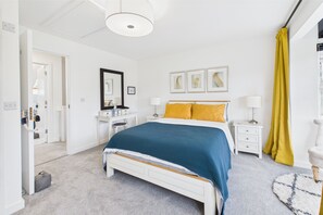 Ein Schlafzimmer mit Bett, Nachttischen, einem Spiegel und Bildern an der Wand.