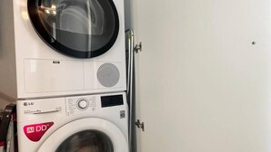 A stacked washer and dryer unit with visible control panels and brand logos.