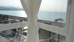 A window with a view of a beach and a body of water.