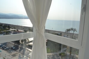 A window with a view of a beach and a body of water.
