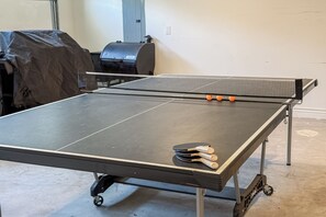 Ein Tischtennis-Tisch mit Netz in einem Raum mit Betonboden.