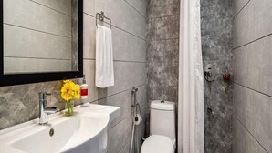 Un baño moderno con un lavabo blanco, inodoro y zona de ducha.
