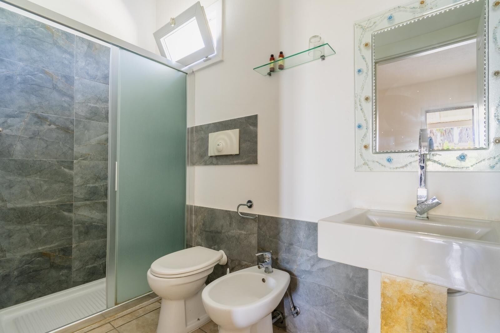 A bathroom with a shower, toilet, and sink.