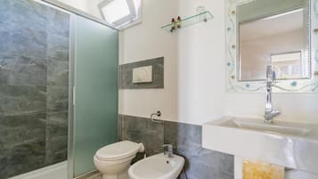 A bathroom with a shower, toilet, and sink.
