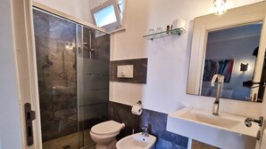 A bathroom with a glass shower enclosure, a toilet, a bidet, and a sink with a mirror. - Elegant 19th-century farmhouse located 700 meters from Baia Verde, Gallipoli (Gallipoli)