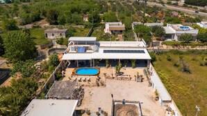A modern house with a swimming pool, surrounded by greenery and a clear view of a cityscape in the distance. - Elegant 19th-century farmhouse located 700 meters from Baia Verde, Gallipoli (Gallipoli)