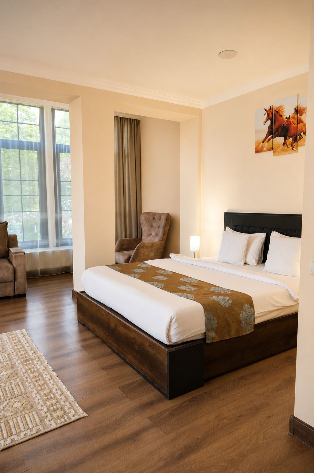 Une chambre d’hôtel avec un grand lit, une chaise, un tapis et une fenêtre avec des rideaux.