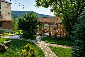 A garden with a gazebo, stone pathway, and outdoor seating.