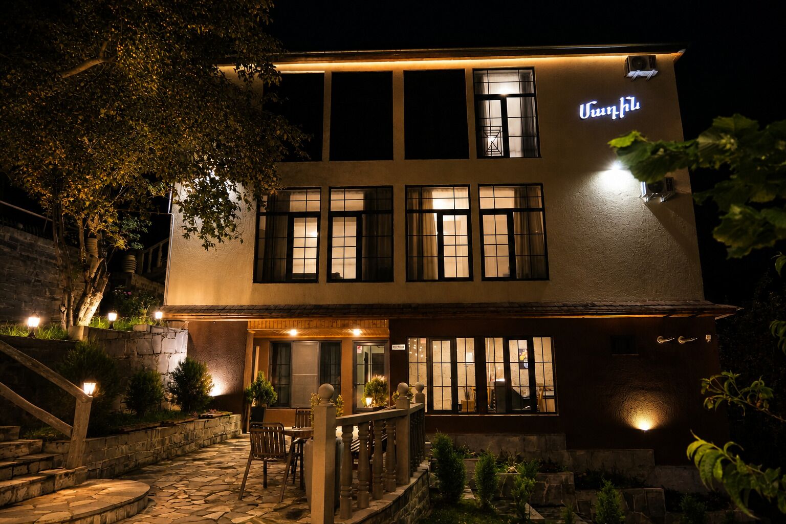 A two-story building with a sign that reads 'Unruh.' There is a staircase leading to the entrance, and the building is surrounded by greenery.