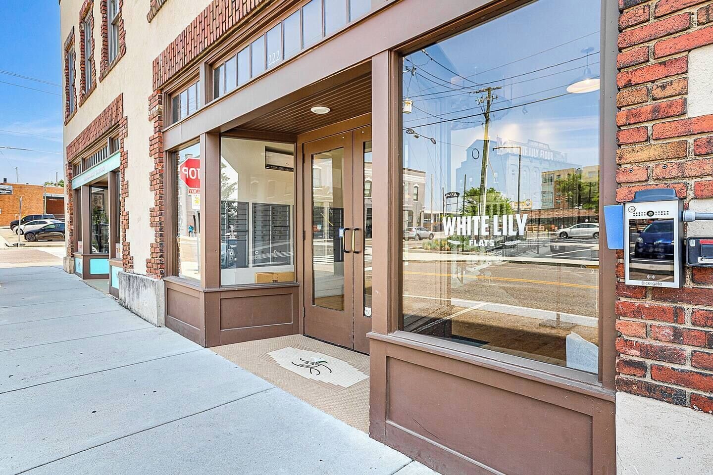 A storefront with a large glass window, a visible door, and a brick wall.