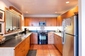 A kitchen with wooden cabinets, a stainless steel refrigerator, a microwave, a stove, and a sink. - Caplan (TOT ID #2147): 3  BR, 2  BA House in The Sea Ranch, Sleeps 6 (The Sea Ranch)