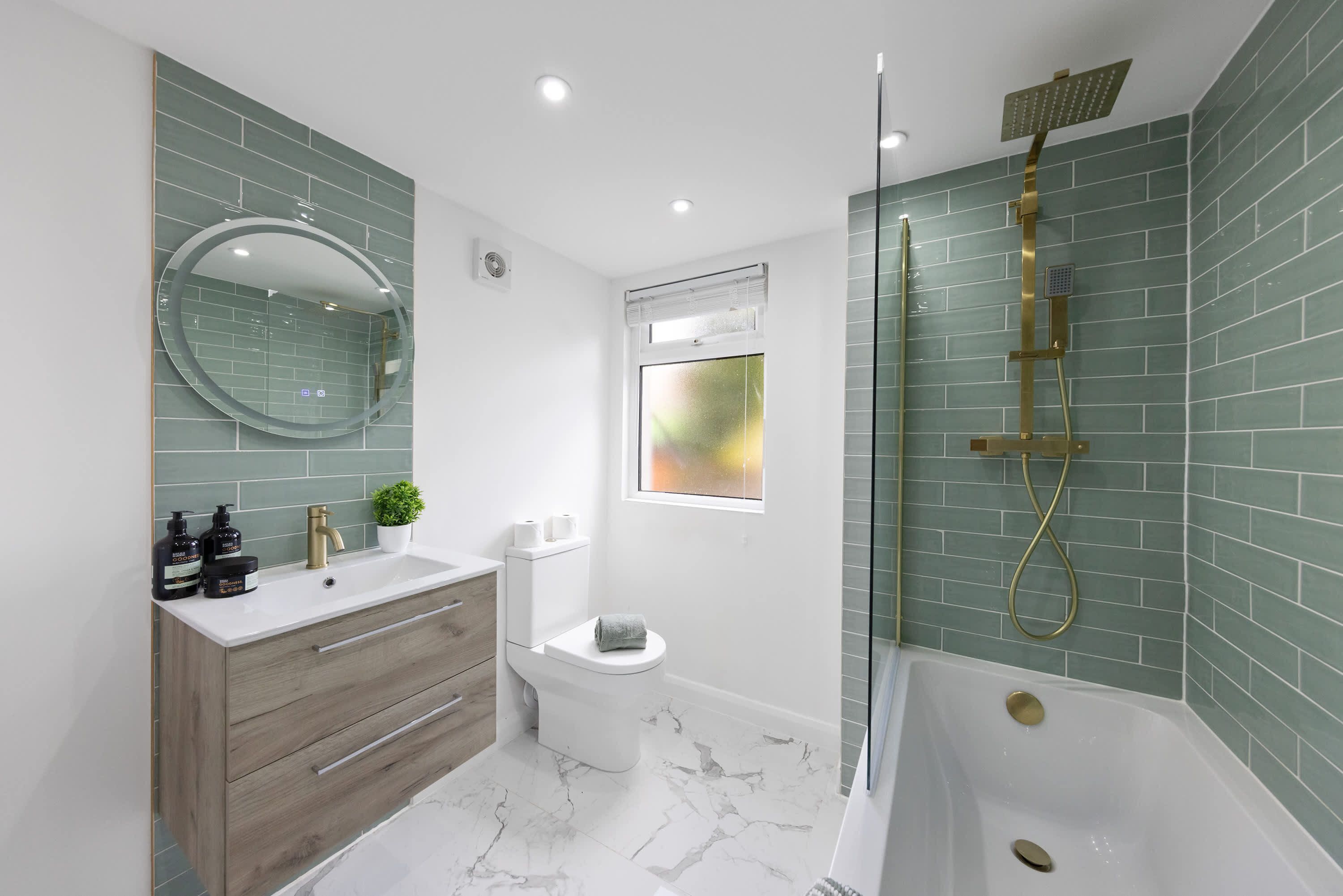 Een moderne badkamer met een wastafel, toilet en bad.