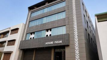A multi-story building with the name 'AKHAND PARAM' on the facade.