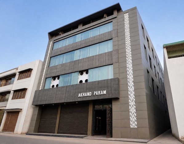 A multi-story building with the name 'AKHAND PARAM' on the facade.