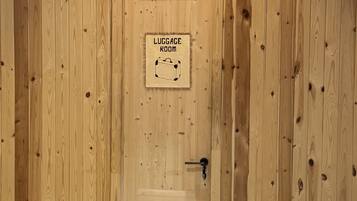 A wooden door with a sign indicating a luggage room.