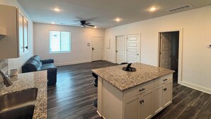 A modern kitchen with granite countertops, a built-in oven, and a ceiling fan. - Newly Built Condo, 6 Mi to Downtown Wichita! (Wichita)