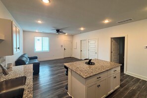 A modern kitchen with granite countertops, a built-in oven, and a ceiling fan. - Newly Built Condo, 6 Mi to Downtown Wichita! (Wichita)