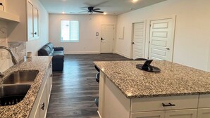 A kitchen with granite countertops, a built-in oven, and a ceiling fan. - Newly Built Condo, 6 Mi to Downtown Wichita! (Wichita)