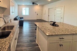 A kitchen with granite countertops, a built-in oven, and a ceiling fan. - Newly Built Condo, 6 Mi to Downtown Wichita! (Wichita)