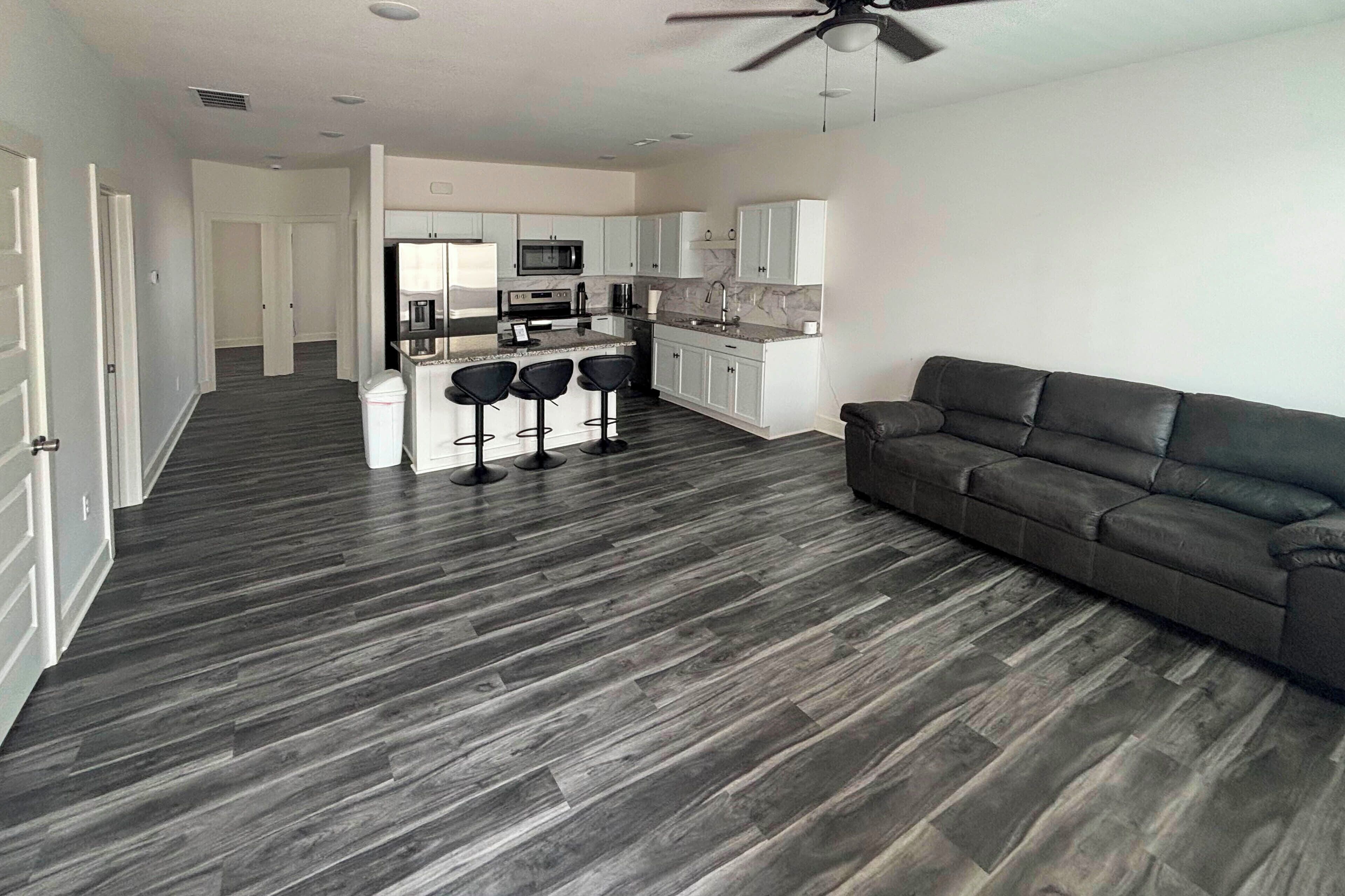 A modern apartment with a kitchen, dining area, and a living room with a sofa.
