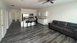 A modern apartment with a kitchen, dining area, and a living room with a sofa. - Newly Built Condo, 6 Mi to Downtown Wichita! (Wichita)