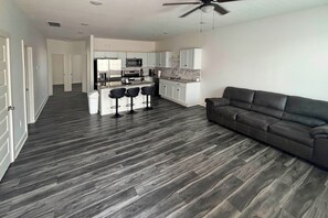 A modern apartment with a kitchen, dining area, and a living room with a sofa. - Newly Built Condo, 6 Mi to Downtown Wichita! (Wichita)