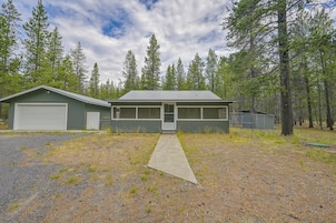 A two-story building with a garage, a covered porch, and a driveway leading to the entrance.