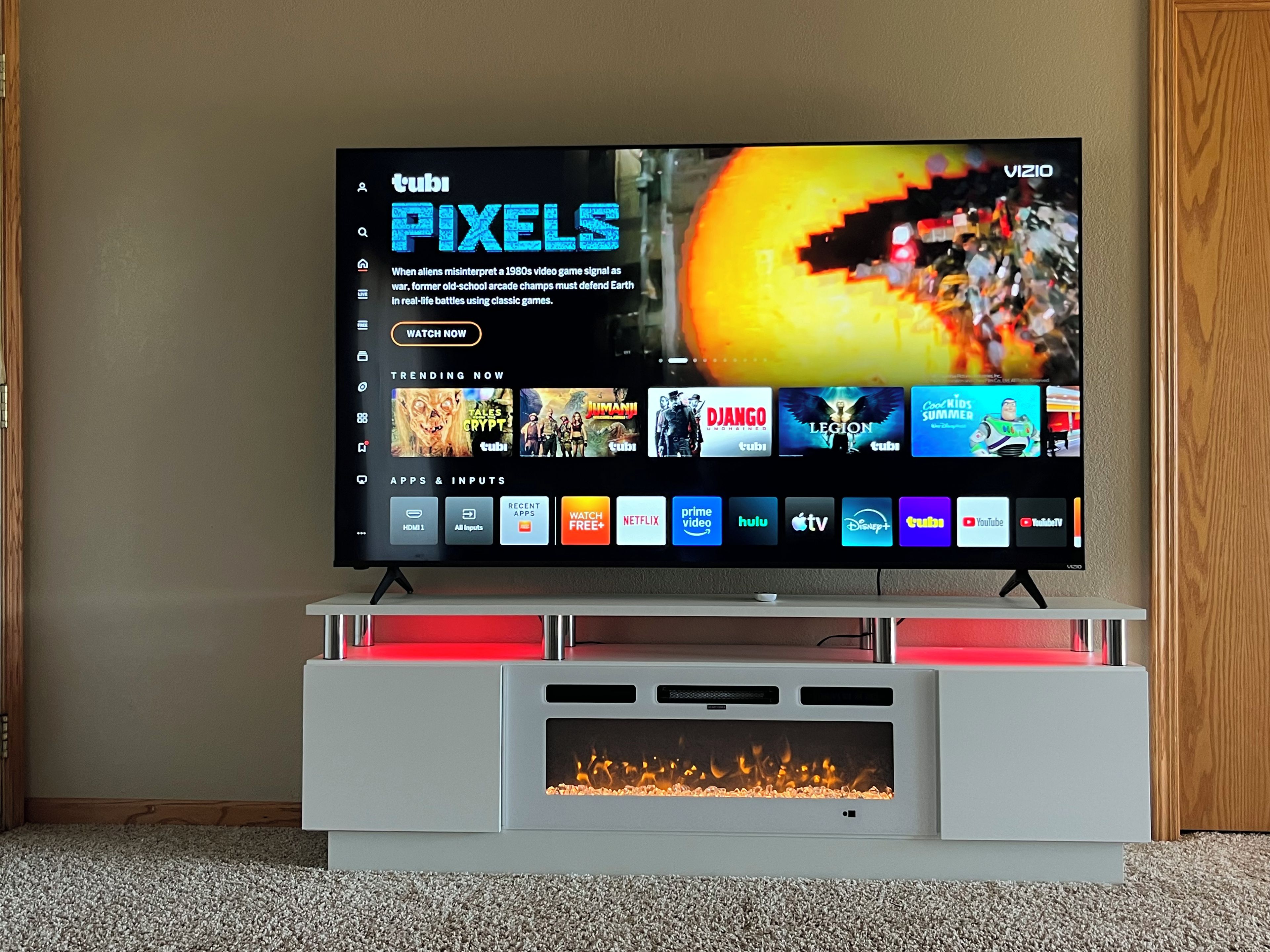 A flat-screen TV on a modern entertainment unit with a fire feature below it.