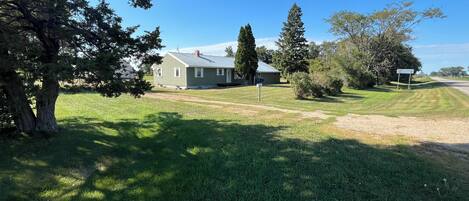 A residential property with a house, a lawn, and a road.