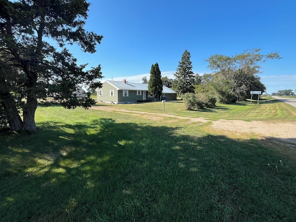 A residential property with a house, a lawn, and a road.