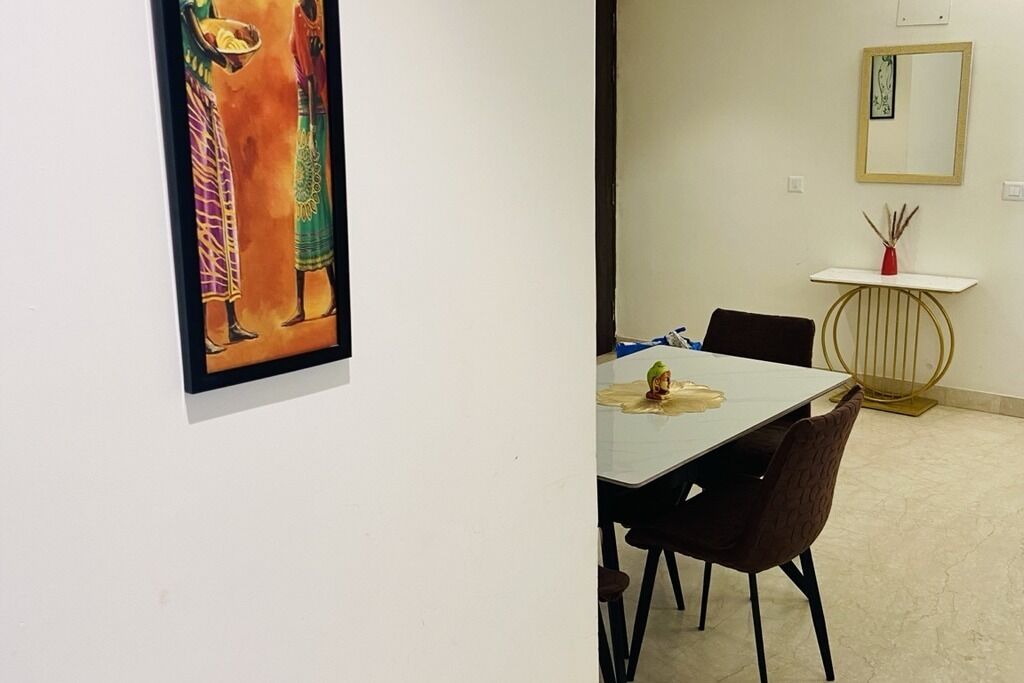 Ein Essbereich mit Tisch, Stühlen und einem an der Wand befestigten Spiegel.