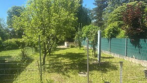 A fenced outdoor area with trees and a grassy path.