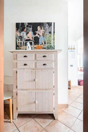 A wooden cabinet with multiple drawers and a painting above it.