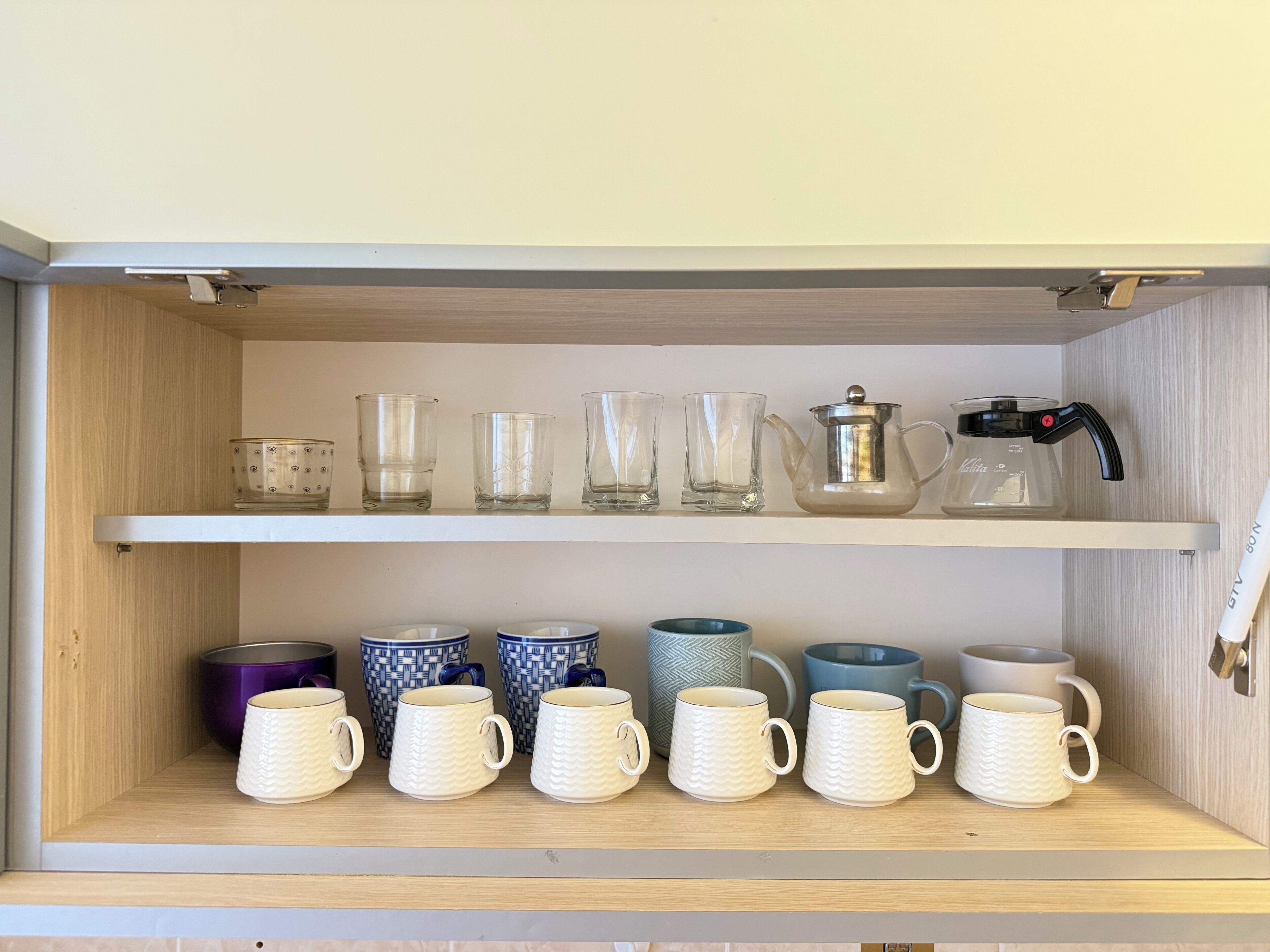 A shelf with various glassware and mugs.