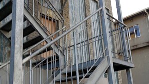 A multi-story building with external metal staircases and balconies. - Groups Accommodation (Durban)