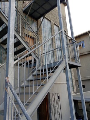 A multi-story building with external metal staircases and balconies. - Groups Accommodation (Durban)