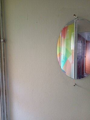 Espejo redondo en una pared con reflejo visible de una habitación.