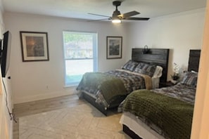 A bedroom with two beds, a ceiling fan, and a window. - House - Sleeps 8 - Hot Tub and Pool (Lewisville)