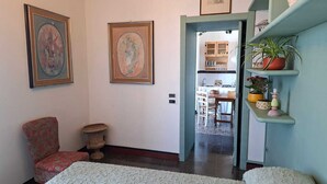 Un pasillo con una silla, una mesita y un acceso a un comedor.
