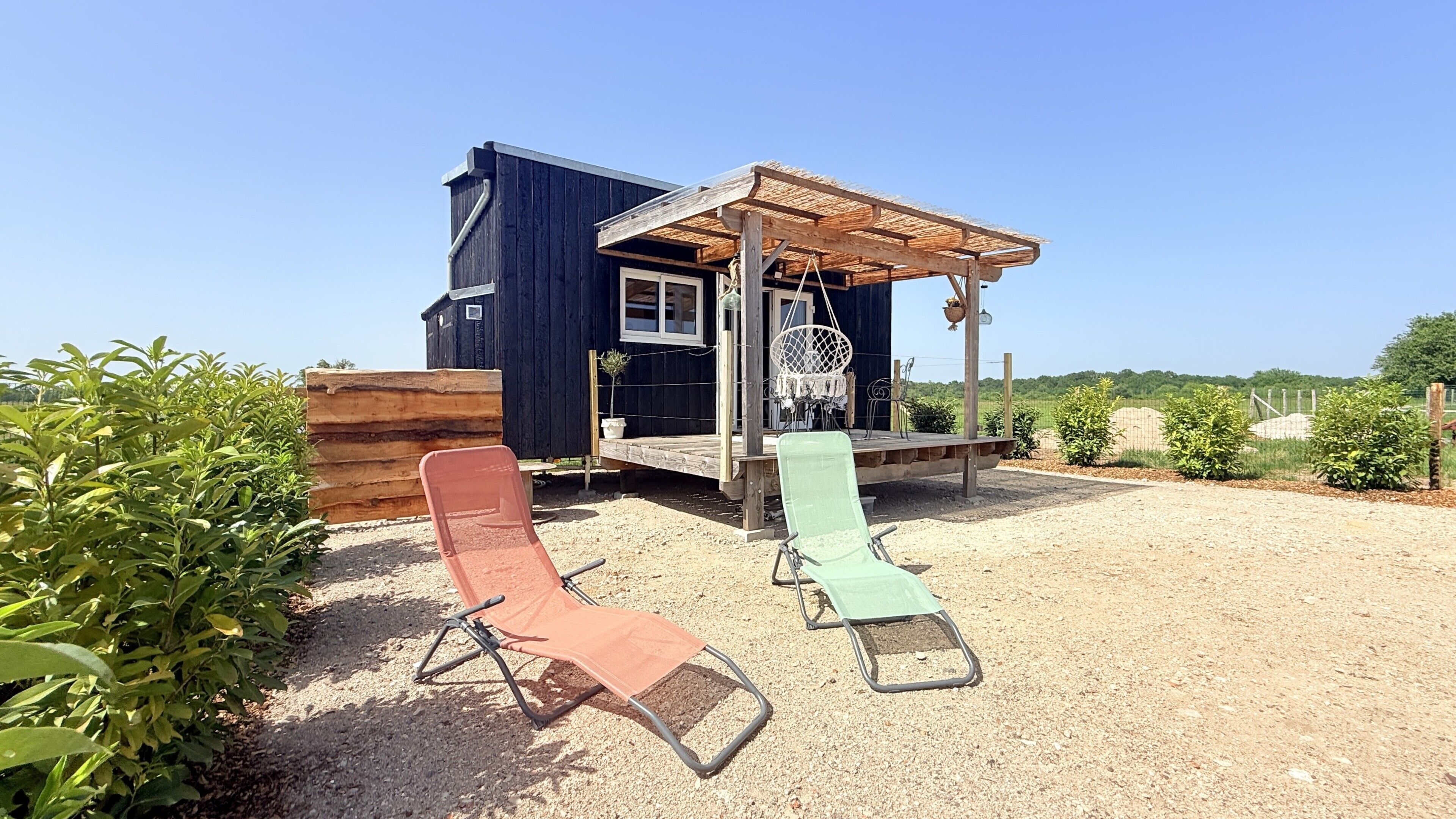 Ein Holzhaus mit Veranda und überdachter Sitzgelegenheit.