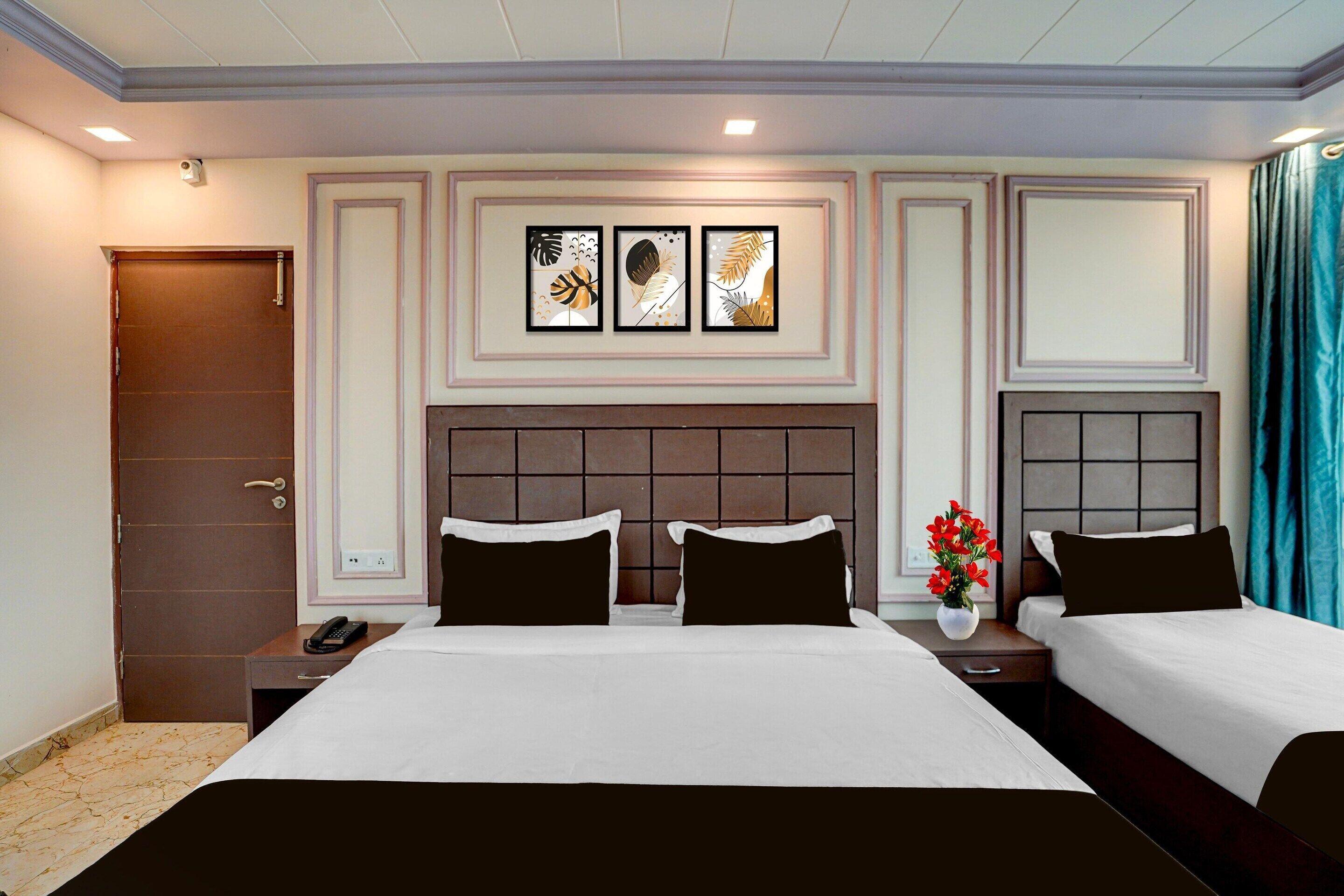 Een hotelkamer met een groot bed, twee nachtkastjes, een telefoon aan de muur en een decoratief paneel.