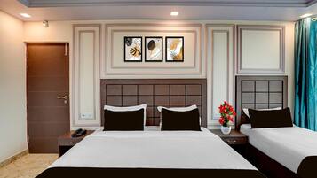 Een hotelkamer met een groot bed, twee nachtkastjes, een telefoon aan de muur en een decoratief paneel.