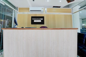 A reception desk with a sign indicating 'TOWNHOUSE OAK' and 'OYO-Serviced.' - Deluxe Prayagraj Bus Terminal (Prayagraj)