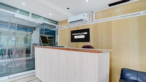A reception desk with a sign that reads 'TOWNHOUSE OAK' and 'oyo-Serviced'. - Deluxe Prayagraj Bus Terminal (Prayagraj)