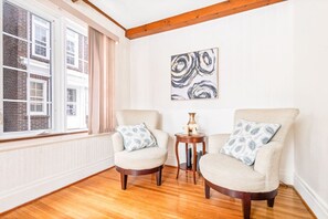 A room with two armchairs, a small table, and a painting on the wall. - Spacious 4BR Near Niagara Falls | Great Location (Niagara Falls)