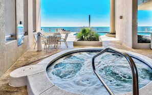 A hot tub with a view of the ocean, surrounded by lounge chairs and a small table. - Palazzo 1206 Top Destination in PCB!/Oceanfront/+Clean/Wifi/Beach Chairs (Panama City Beach)