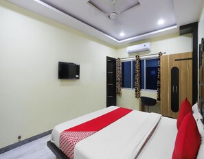Un dormitorio con cama, televisor, aire acondicionado y armario.