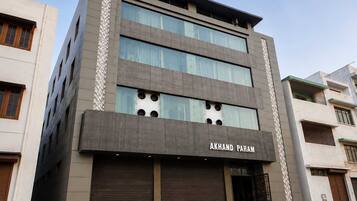 A multi-story building with a modern facade, featuring a prominent signage for 'AKHAND PARAM'.