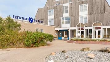 Een hotel genaamd Fletcher Hotels, met een modern design, een gevel van baksteen en een aangelegde entree.